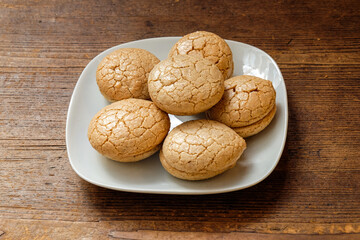 A plate of traditional Turkish sweets( Acıbadem ) on a wooden floor