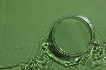 Stylish presentation for product. Glass podium in water on pale green background, top view. Space for text