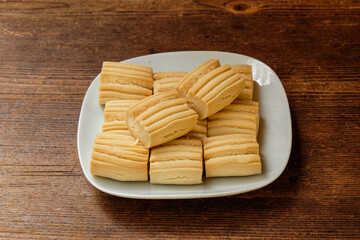 A plate of traditional Turkish sweets( Un Kurabiyesi) on a wooden floor