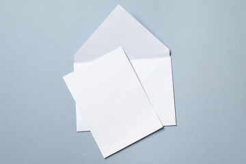 Letter envelope and card on grey background, top view. Space for text