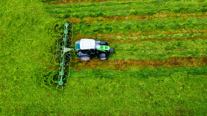 Ein Landwirt wendet mit Traktor das abgem&auml;hte Gras (Luftaufnahme)