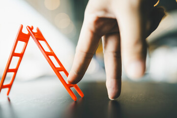 Businessman with his fingers on the table, climbing the stairs to success. Concept of growth and...