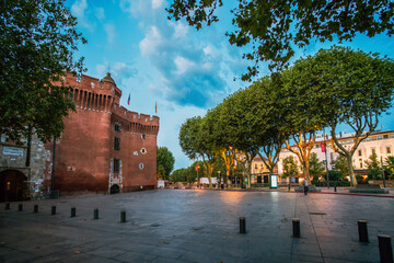 Fortress  Porte Notre-Dame in Perpignan. Twilights in summertime. Gorgeous large trees  (plane...