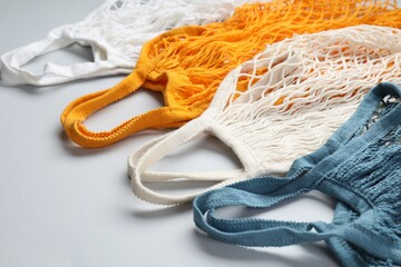 Different string bags on light grey background, closeup
