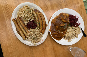 A plate of German food with chicken bratwurst sausages, potatoes and Red Cabbage