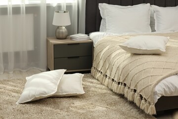 Soft white pillows on floor in bedroom