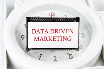 Business analysis and strategy as concept. DATA DRIVEN MARKETING text on a business card on a stand on a lying watch