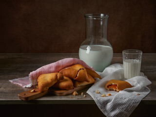 fresh pies with dried apricots and a glass of milk