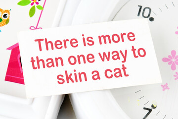 There is more than one way to skin a cat text text on the business card on the background of the clock