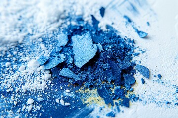 Crushed eyeshadows on a blue background, closeup of photo