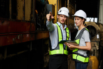 engineers or workers checking and pointing to something at construction train station