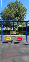 Swings in park on sunny day of the year