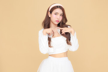 Pretty Asian fashionable office entrepreneur woman curly long hair and Korean make up style on lovely face in white casual suit trendy pose gesture on isolated beige background indoor studio.