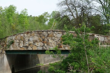 Image of a stone pedestrian bridge crossing a stream