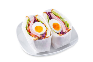 Japanese Wanpaku sandwich with egg, red cabbage and ham on a white isolated background