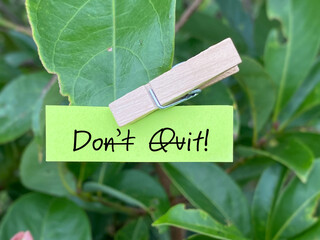 Don't quit or do it note message with nature background. Stock photo.