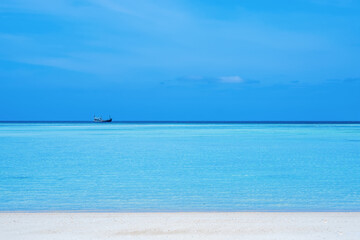 Mai Ngam Beach at Surin Island A small fishing boat floating in the middle of the sea as far as the eye can see. near white sand beach Island in the Andaman Sea, Kuraburi, Phang Nga, Thailand.