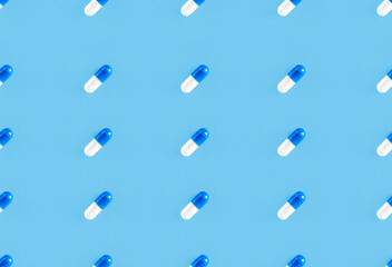 Two-piece pills on blue background. Medical pharmacy seamless pattern
