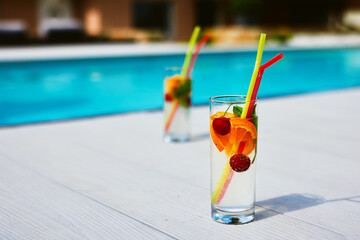 Two glass of cocktail by the pool