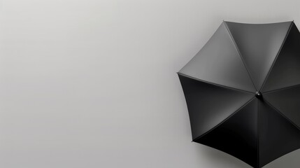 Striking top view of black umbrella with a soft grey gradient background and copy space for advert text.