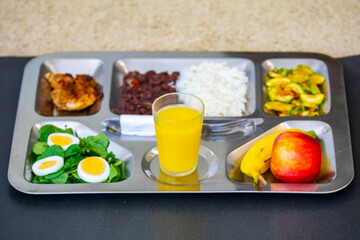 Typical steel tray with nutritious rustic food. Traditional university and popular tray