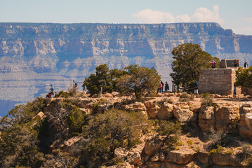 Scenic view of Grand Canyon with vast landscape, rock formations, visitors enjoying overlook, small...