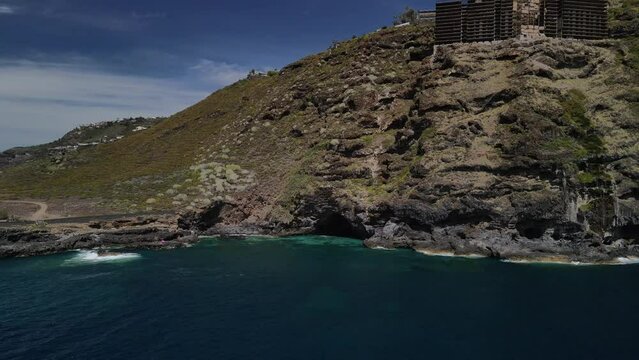Fly across a rough tenerife coast line called Baja de los Cristianos at Caleton with splashing wavesTen