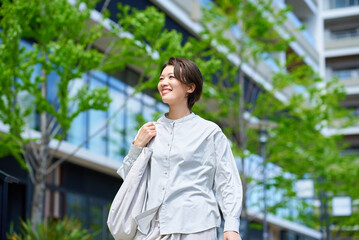 ショッピングバッグを持って街を歩く女性