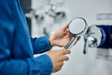 Close-up of a male holding a shower head, searching for the right one, for his bathroom.