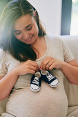 Happy, pregnant woman and shoes on belly in home for reveal of boy gender, journey and experience...