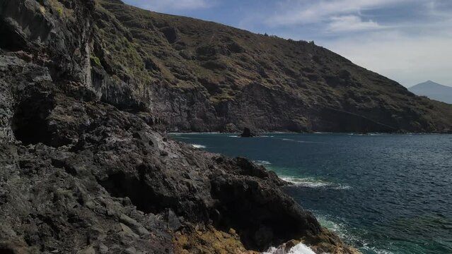 Fly across a rough tenerife coast line called Baja de los Cristianos at Caleton with splashing wavesTen