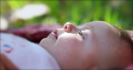 Fototapeta premium Newborn baby infant lying on grass outdoors in dreamy day