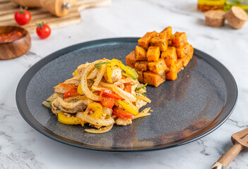 Black plate with food and wooden spoons