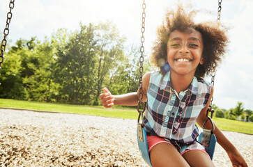 African girl, portrait and smile with swing, park and nature for outdoor fun or play with fresh...