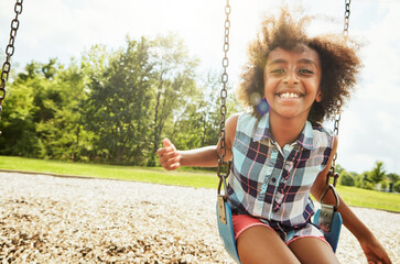 African girl, portrait and smile with swing, park and nature for outdoor fun or play with fresh air. Child, joy and playground with summer, freedom and school holiday or break outside with happiness