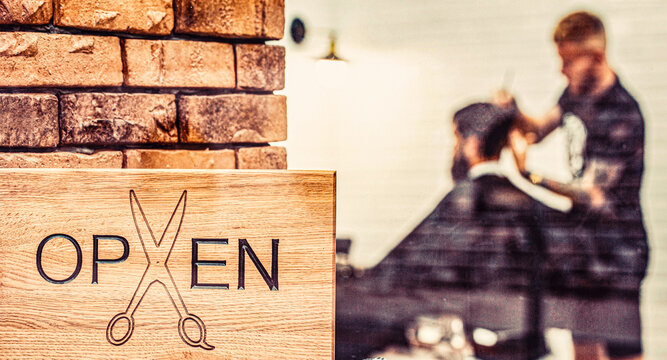 Open sign crafted with on wooden board in window. Bearded man getting haircut. Barbershop salon. Open barder shop. Hairdresser or barber