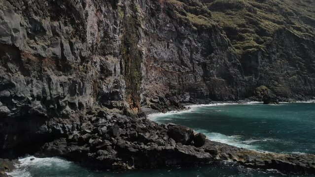 Fly across a rough tenerife coast line called Baja de los Cristianos at Caleton with splashing wavesTen