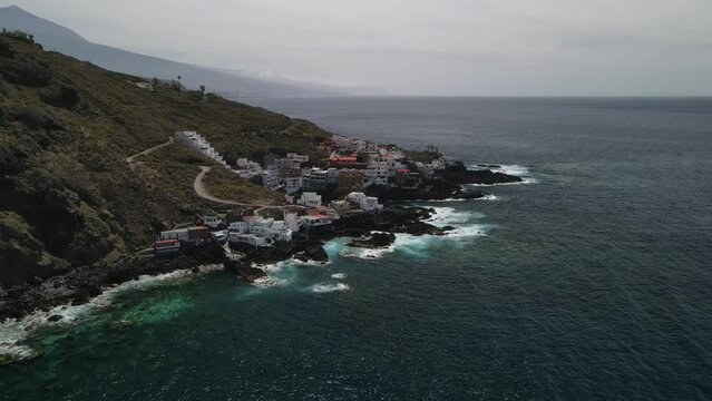 Fly across a rough tenerife coast line called Baja de los Cristianos at Caleton with splashing wavesTen