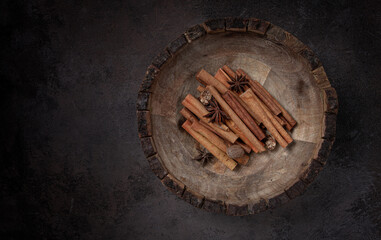 cinnamon sticks, with nutmeg and anise star, in a wooden plate, top view, no people,