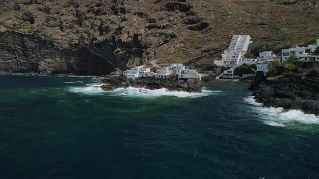 Fly across a rough tenerife coast line called Baja de los Cristianos at Caleton with splashing wavesTen