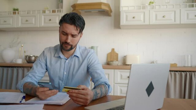 Man online paying credit card on phone. Businessman banker working on laptop, paying mobile phone money shopping ecommerce enter secure code safe transaction at home. Online paying ecommerce concept.