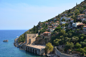 an old town on the mountain with blue water and blue sky