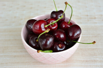 a bowl of sweet cherries with water drops close up