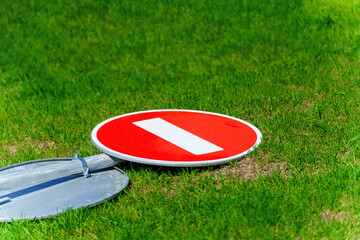Car 'Stop' sign laying on grass, signaling 'end of restrictions'