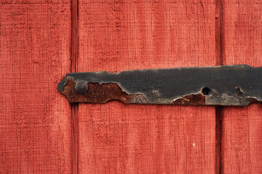 rusted metal hinge mount holding up an old wooden garage door