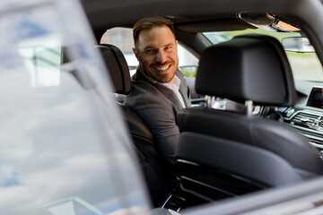 Welcoming smile from a joyful driver in a luxury sedan on a sunny day