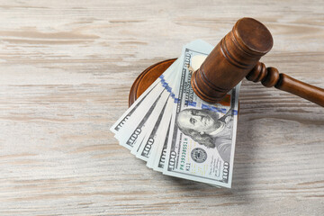 Judge's gavel and money on wooden table. Space for text