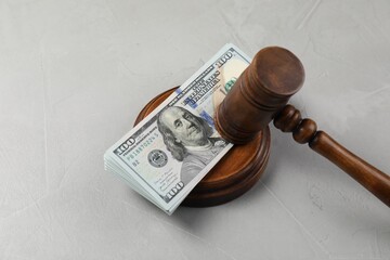Judge's gavel and money on grey table