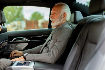 Distinguished senior gentleman enjoying a peaceful ride in a luxury car