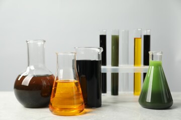 Laboratory glassware with different types of oil on white table